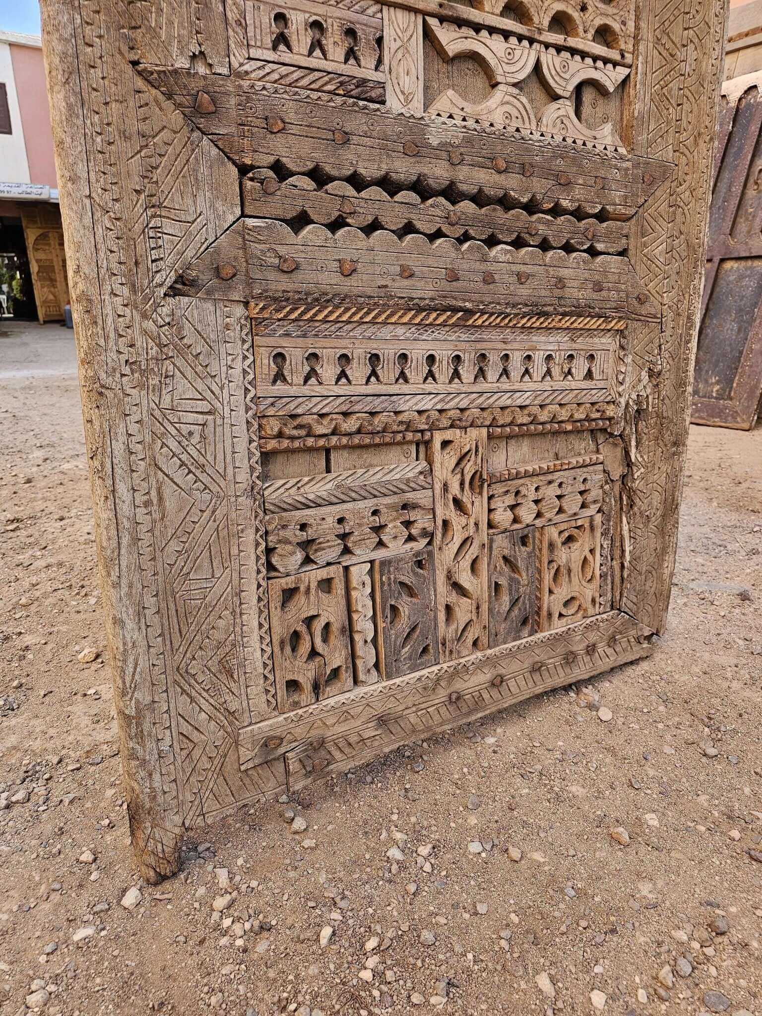 Hand-aged floral wooden door — close detail of leaf carving