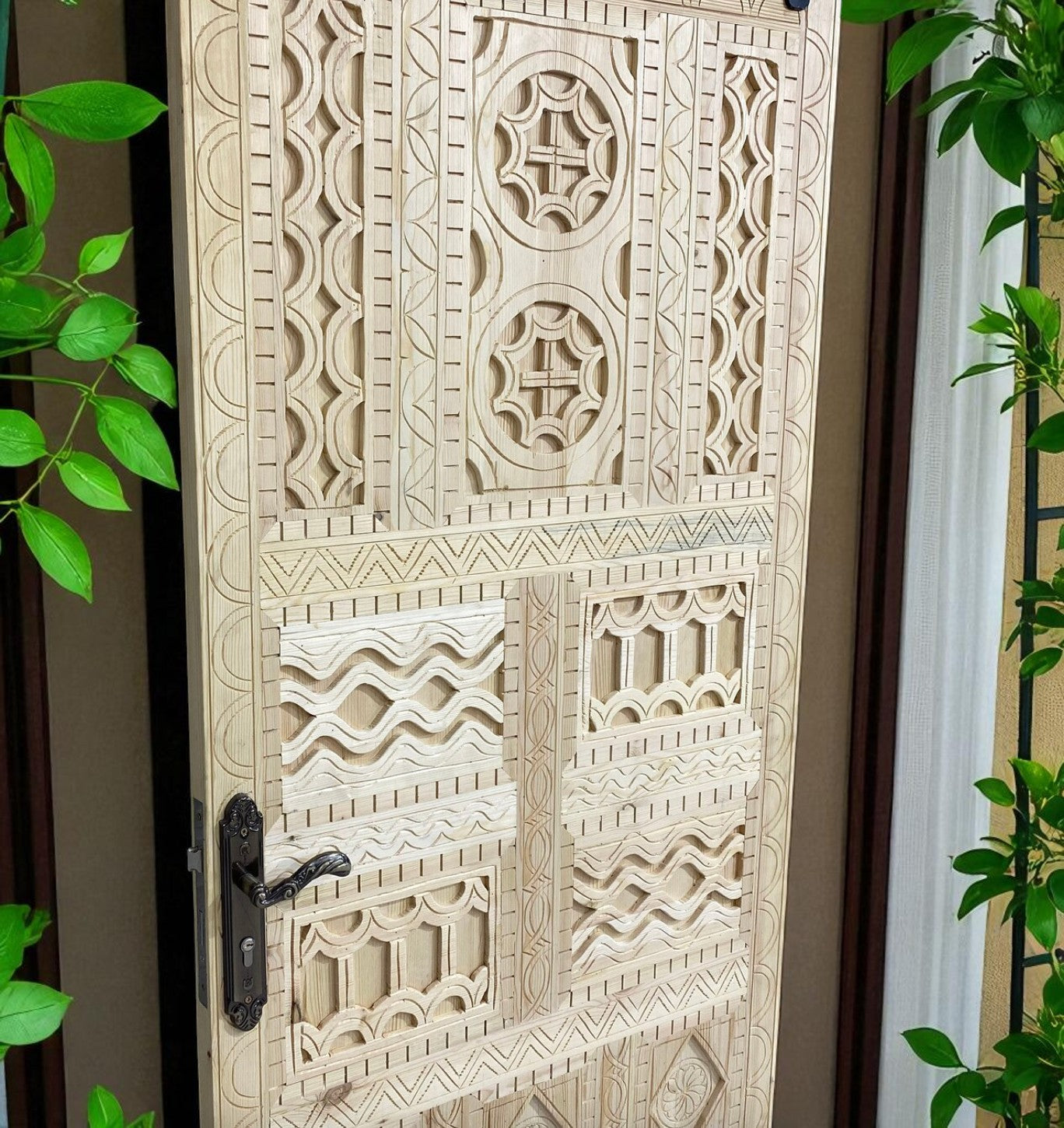 Carved wooden door with geometric patterns and metal handle.
