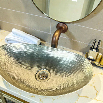hammered brass bathroom vessel sink with a polished finish and stylish faucet, set against a modern countertop