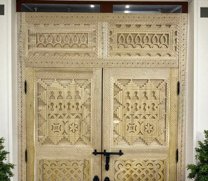 Intricately carved wooden double doors with geometric and floral patterns.