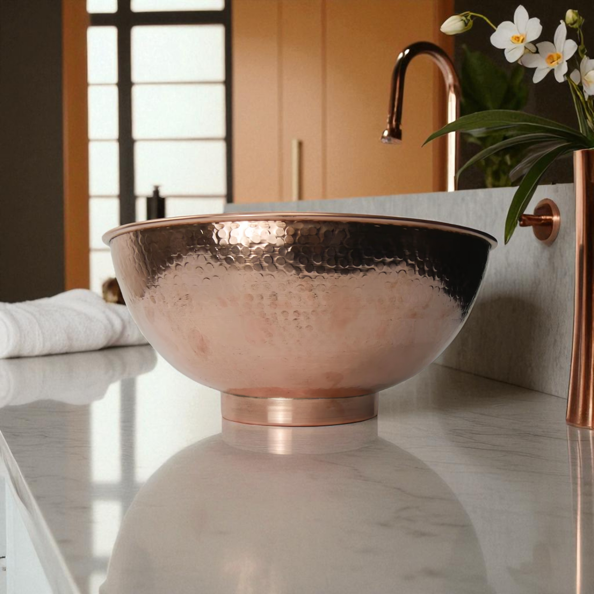 Copper vessel sink with hammered texture on marble countertop in bathroom.