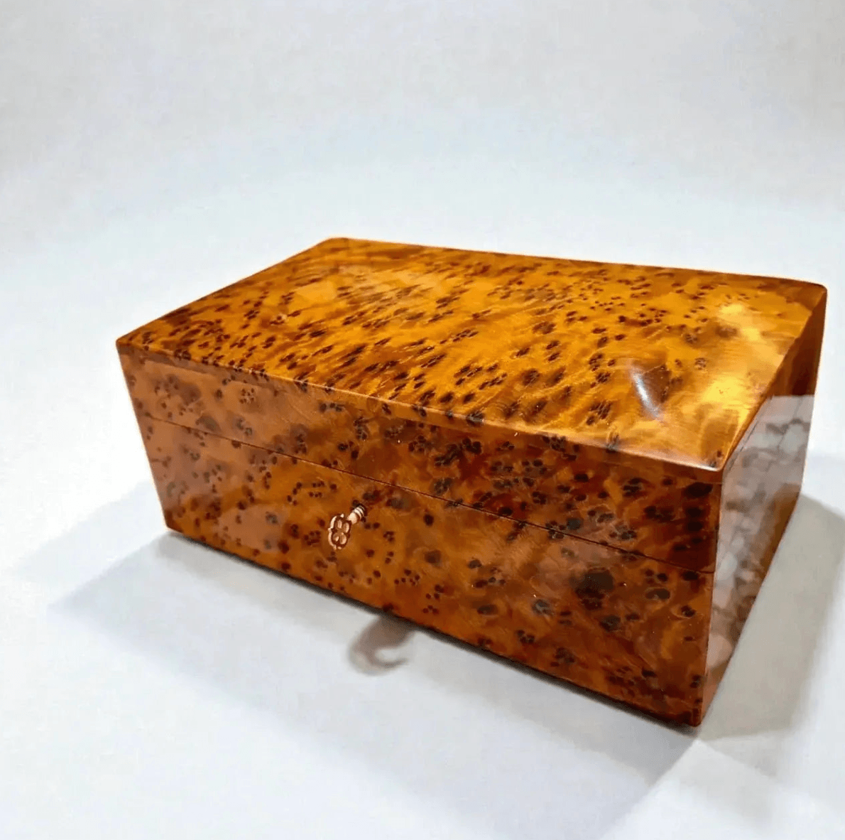 Wooden jewelry box with a distinctive grain pattern on a white background