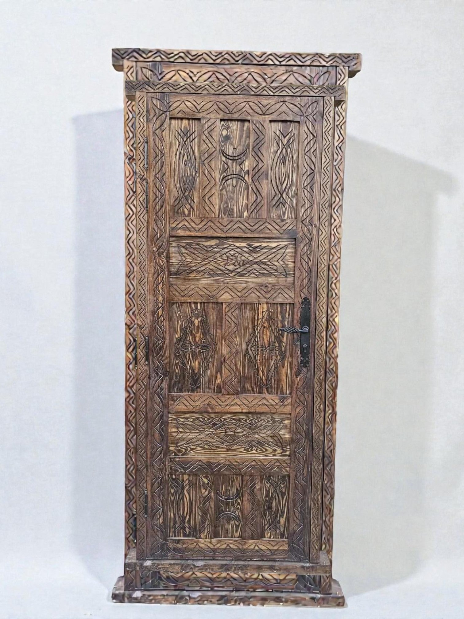 AtlasMuseCrafts antique Moroccan door made of natural wood with intricate Berber carving and a dark metal handle.