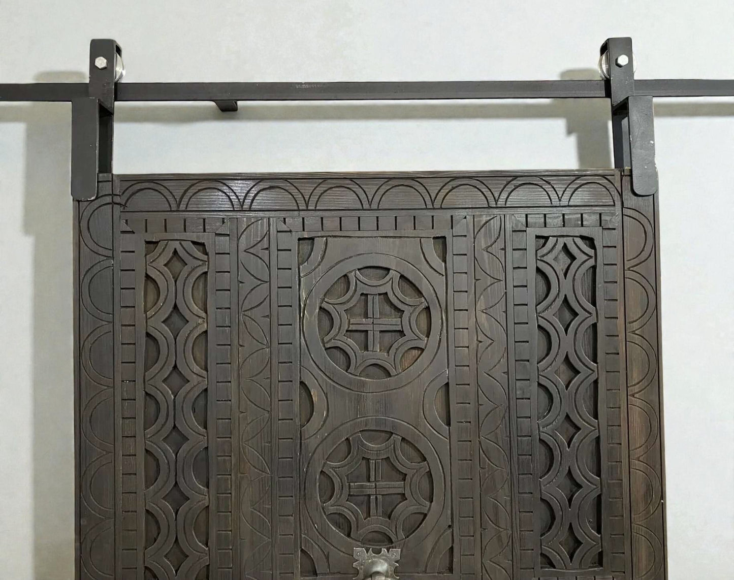 AtlasMuseCrafts dark wood sliding barn door with intricate traditional floral carving and geometric patterns.