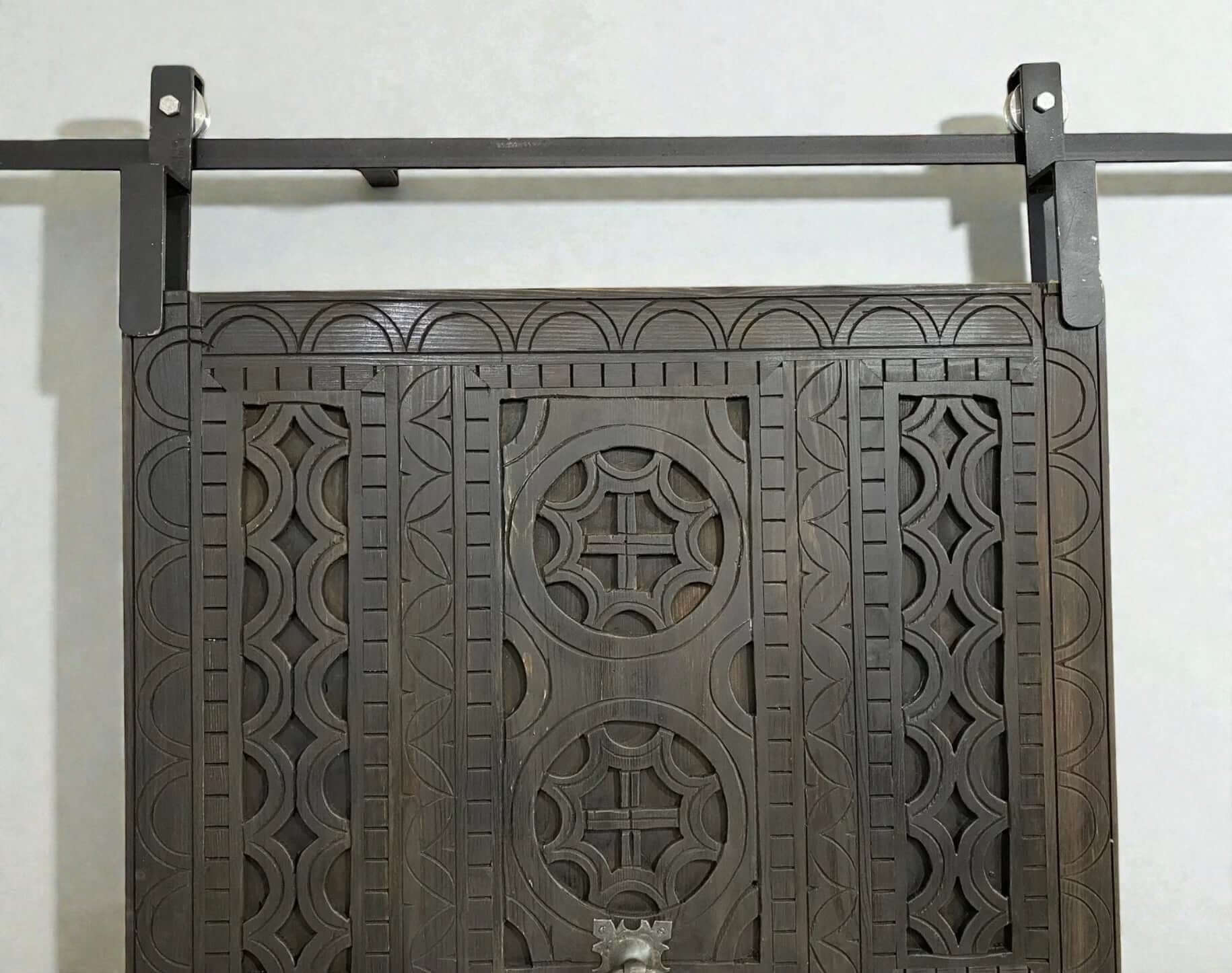 AtlasMuseCrafts dark wood sliding barn door with intricate traditional floral carving and geometric patterns.