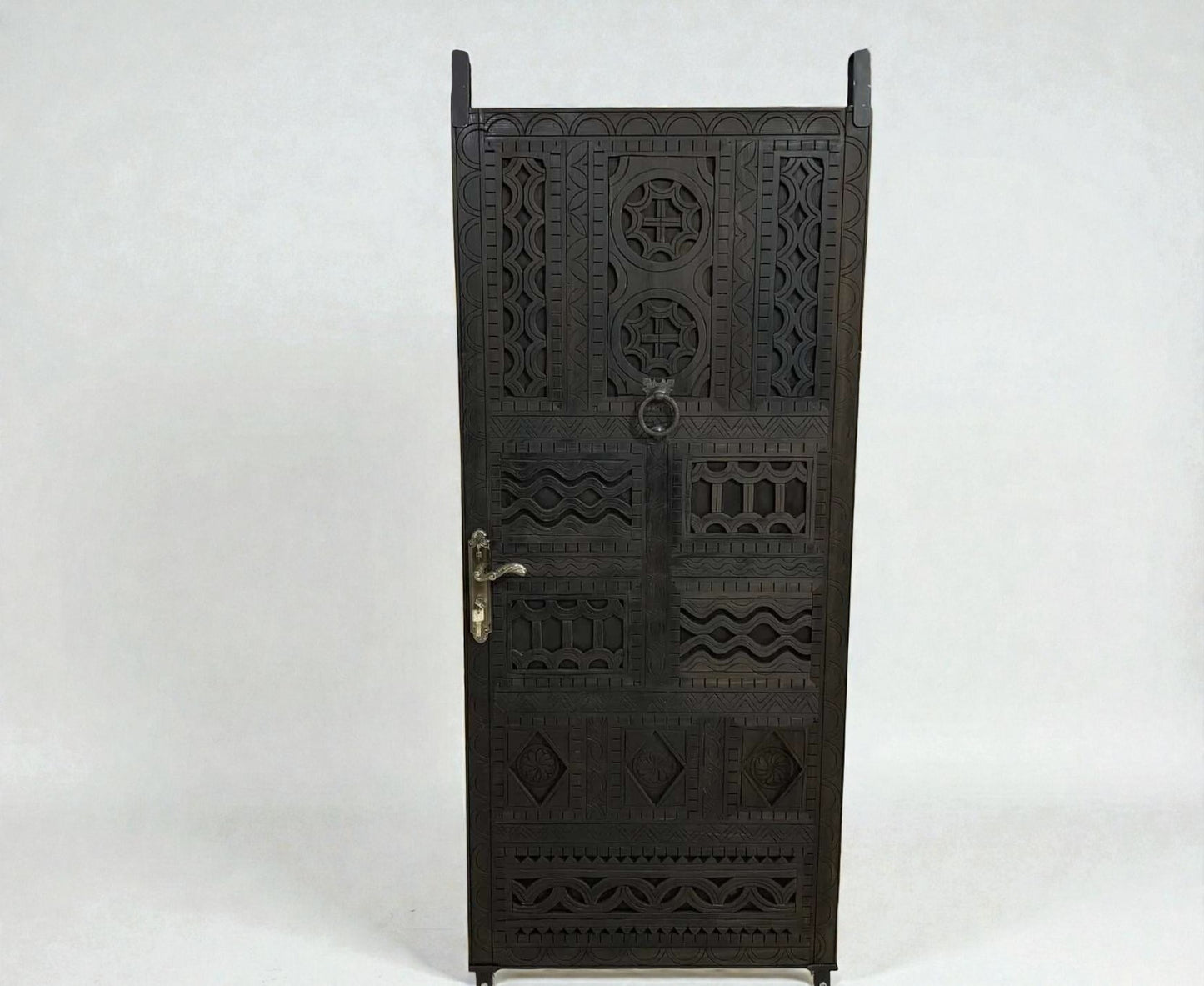 AtlasMuseCrafts dark wood door with intricate floral and geometric carvings, featuring a ring pull and ornate handle.