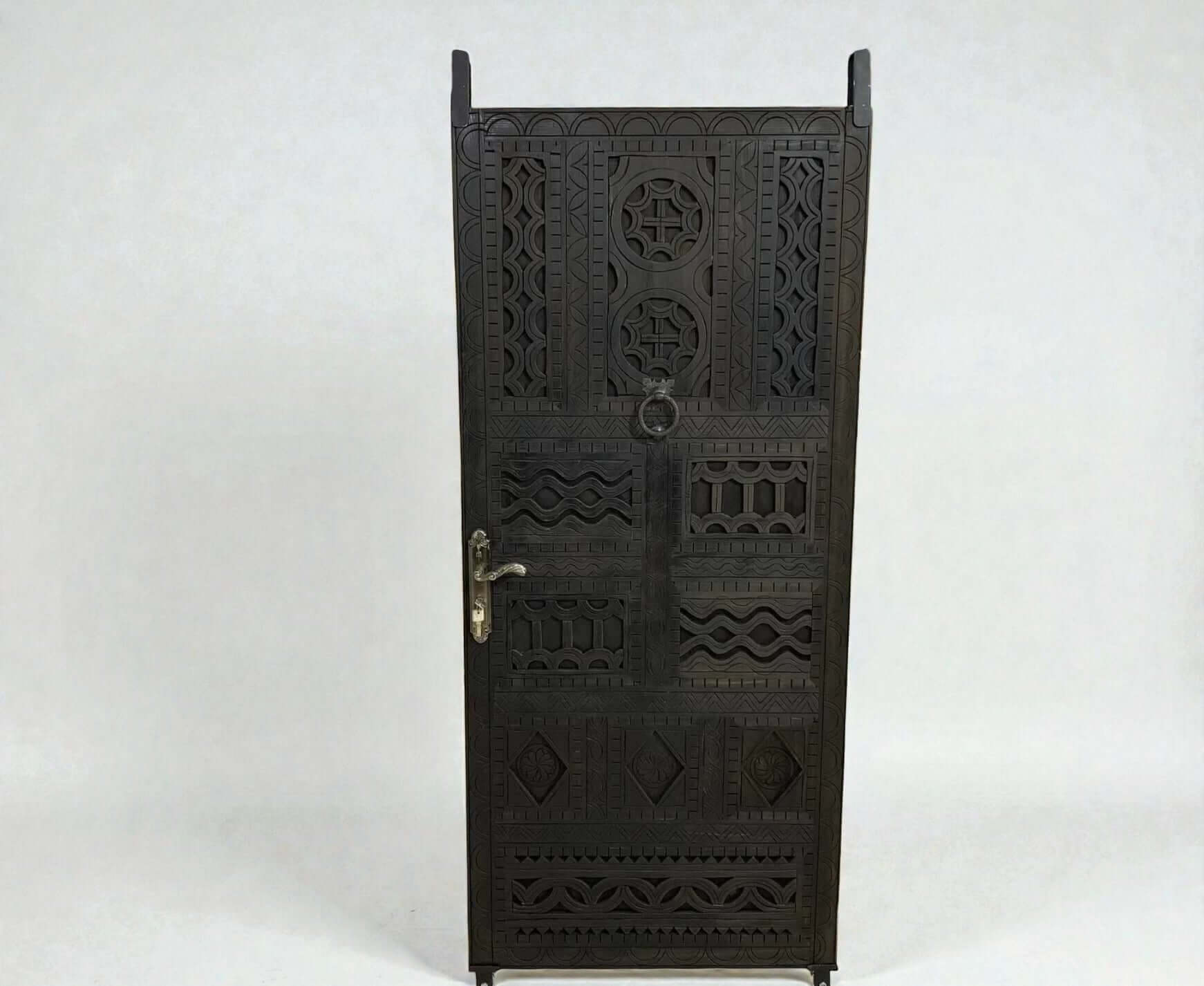 AtlasMuseCrafts dark wood door with intricate floral and geometric carvings, featuring a ring pull and ornate handle.