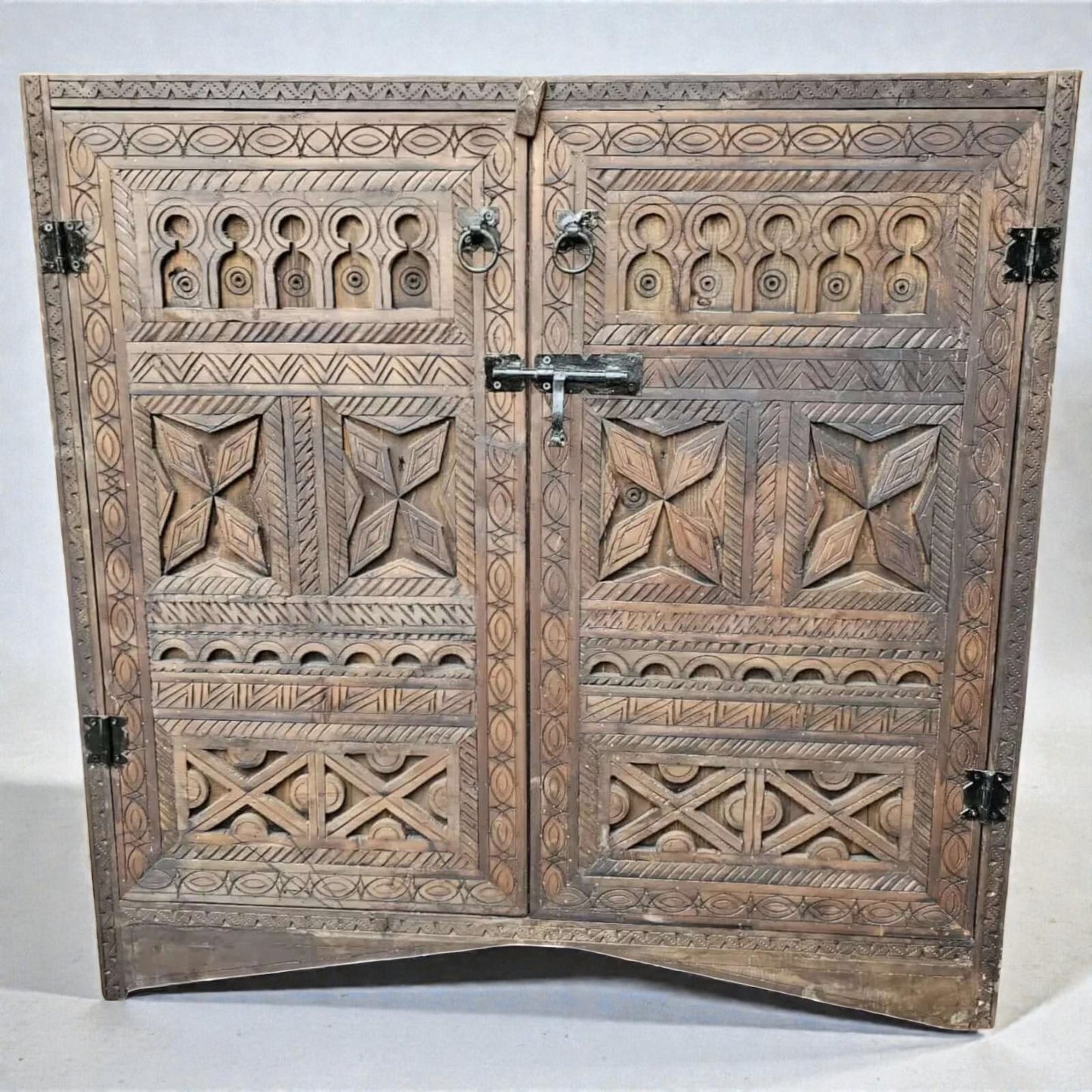 AtlasMuseCrafts handcrafted wooden cabinet with intricate Berber carvings and rustic boho style. Features double doors with metal latch and ring pulls.