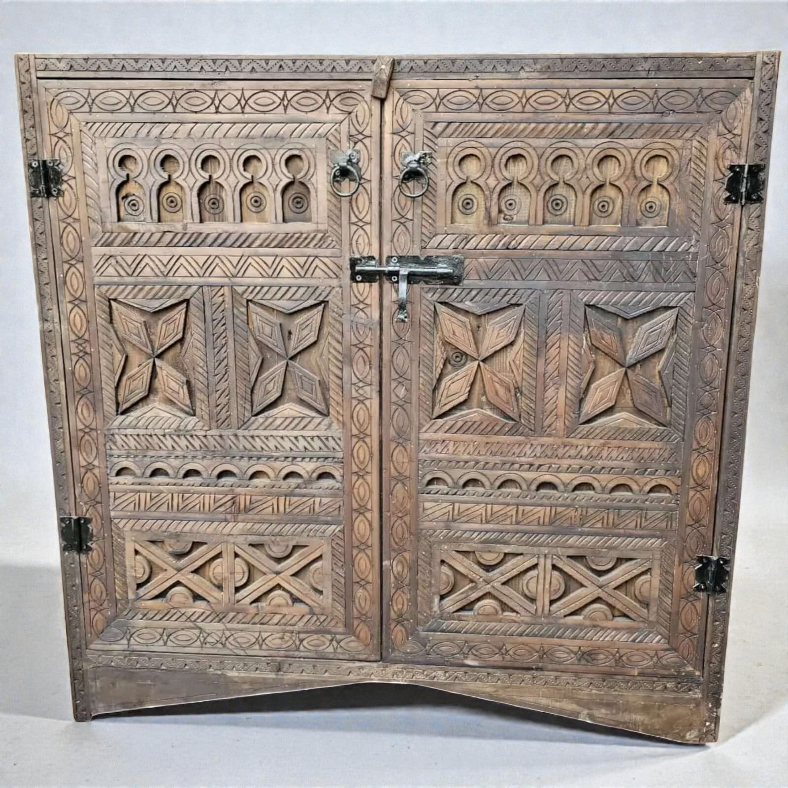 AtlasMuseCrafts handcrafted wooden cabinet with intricate Berber carvings and rustic boho style. Features double doors with metal latch and ring pulls.