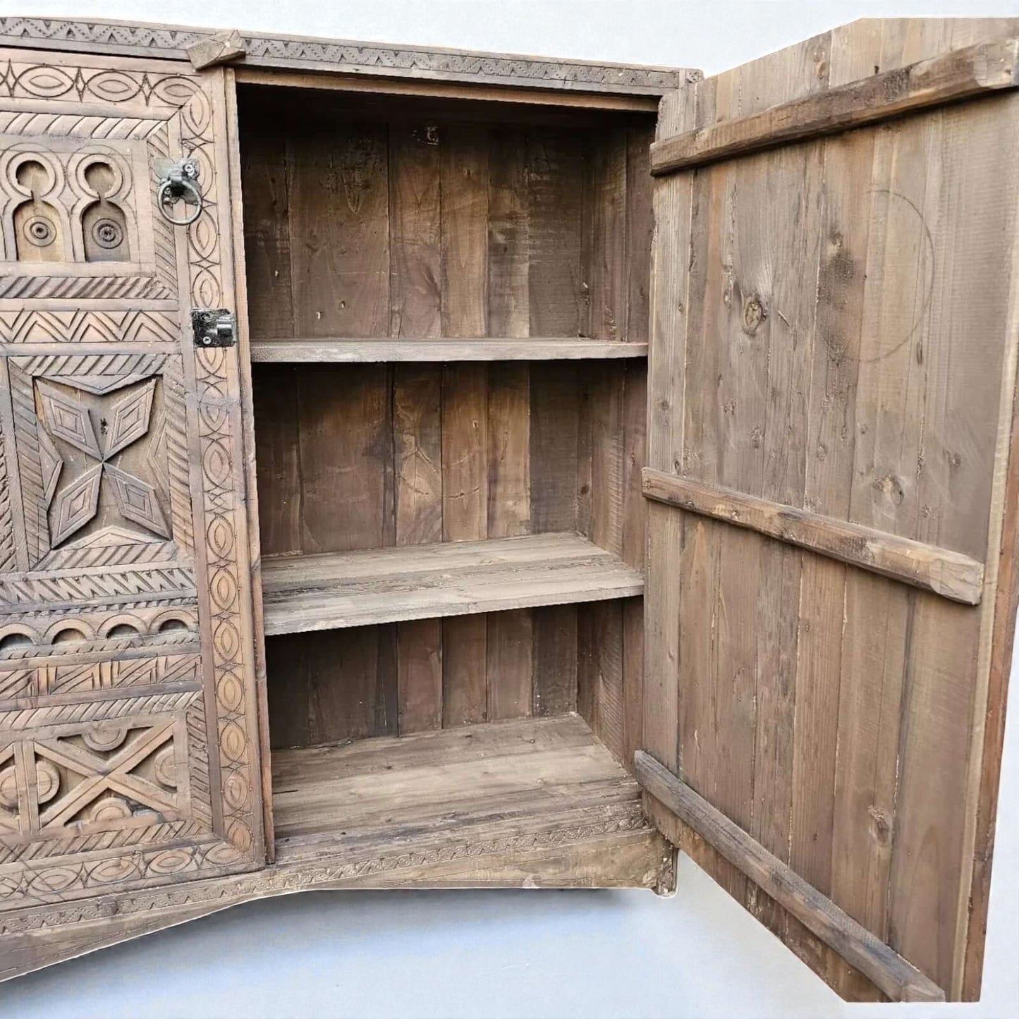 AtlasMuseCrafts handcrafted wooden cabinet with intricate Berber carvings and rustic boho style. Features open doors revealing shelves.