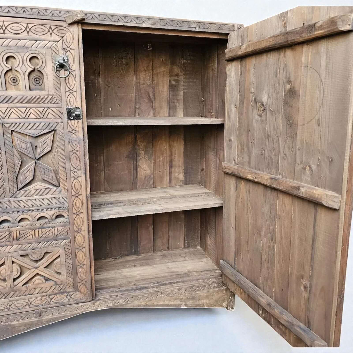 AtlasMuseCrafts handcrafted wooden cabinet with intricate Berber carvings and rustic boho style. Features open doors revealing shelves.