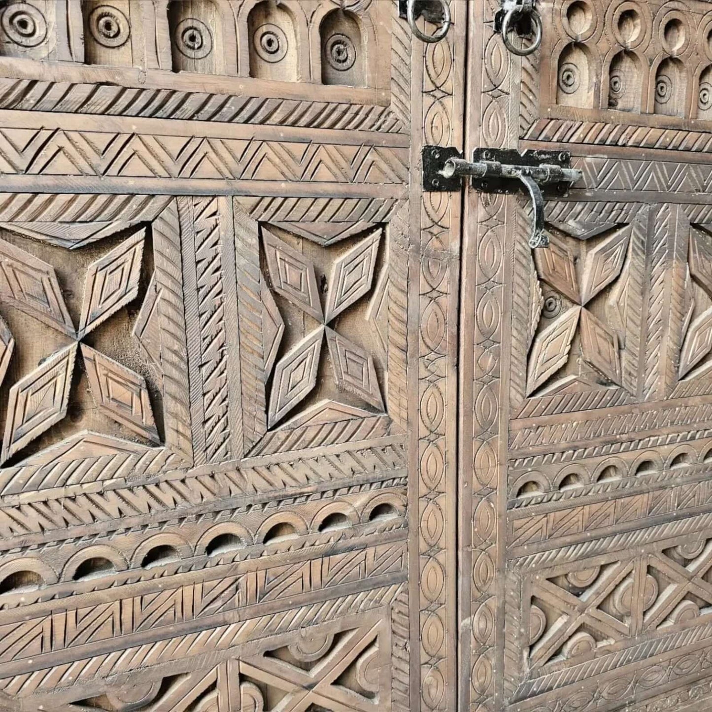 AtlasMuseCrafts handcrafted wooden cabinet with intricate Berber carvings and rustic boho style. Features metal latch.