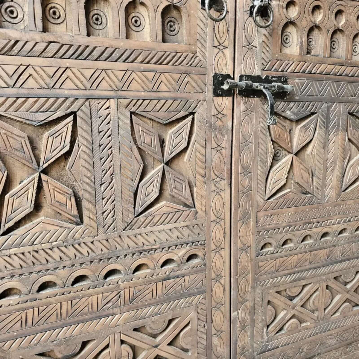 AtlasMuseCrafts handcrafted wooden cabinet with intricate Berber carvings and rustic boho style. Features metal latch.