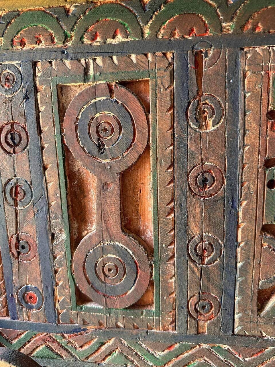 AtlasMuseCrafts handmade wooden door with brass knobs, featuring intricate Moroccan geometric carvings and natural wood finish.