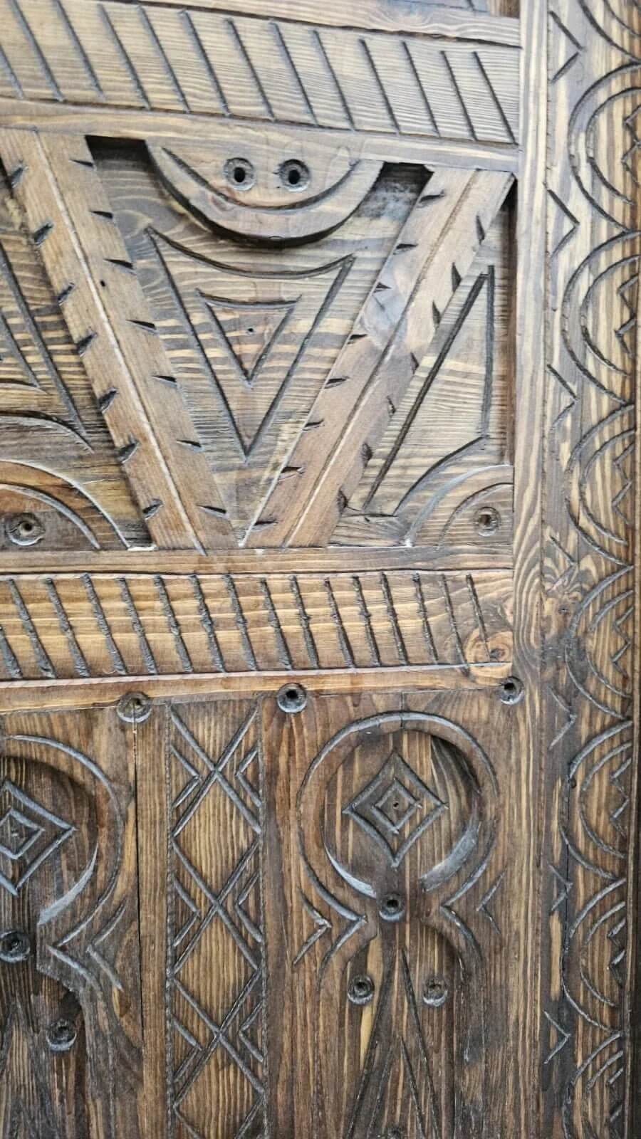 AtlasMuseCrafts antique Moroccan door, natural wood with intricate Berber carving. Features geometric patterns and a rustic finish.