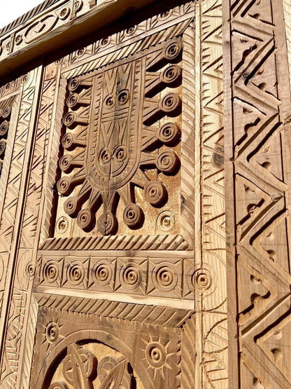 AtlasMuseCrafts antique Moroccan double door with intricate hand-carved natural wood panels featuring geometric and arabesque patterns.