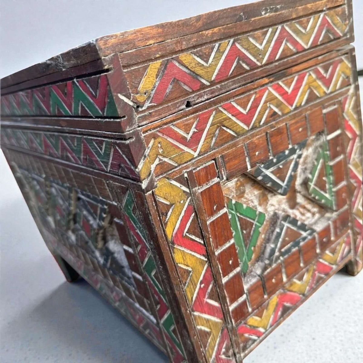 AtlasMuseCrafts custom Moroccan wood cabinet with hand-carved Berber patterns in red, yellow, and green.