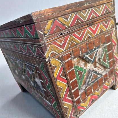 AtlasMuseCrafts custom Moroccan wood cabinet with hand-carved Berber patterns in red, yellow, and green.