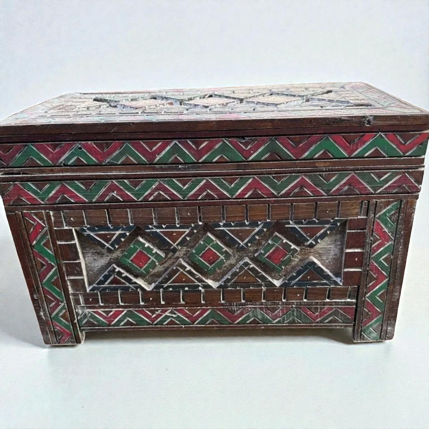 AtlasMuseCrafts custom Moroccan wood cabinet with hand-carved Berber patterns in red, green, and white.