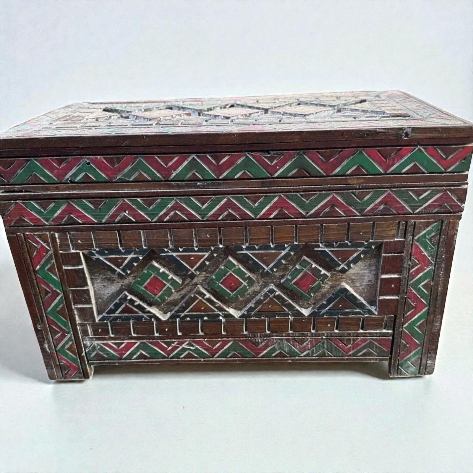 AtlasMuseCrafts custom Moroccan wood cabinet with hand-carved Berber patterns in red, green, and white.