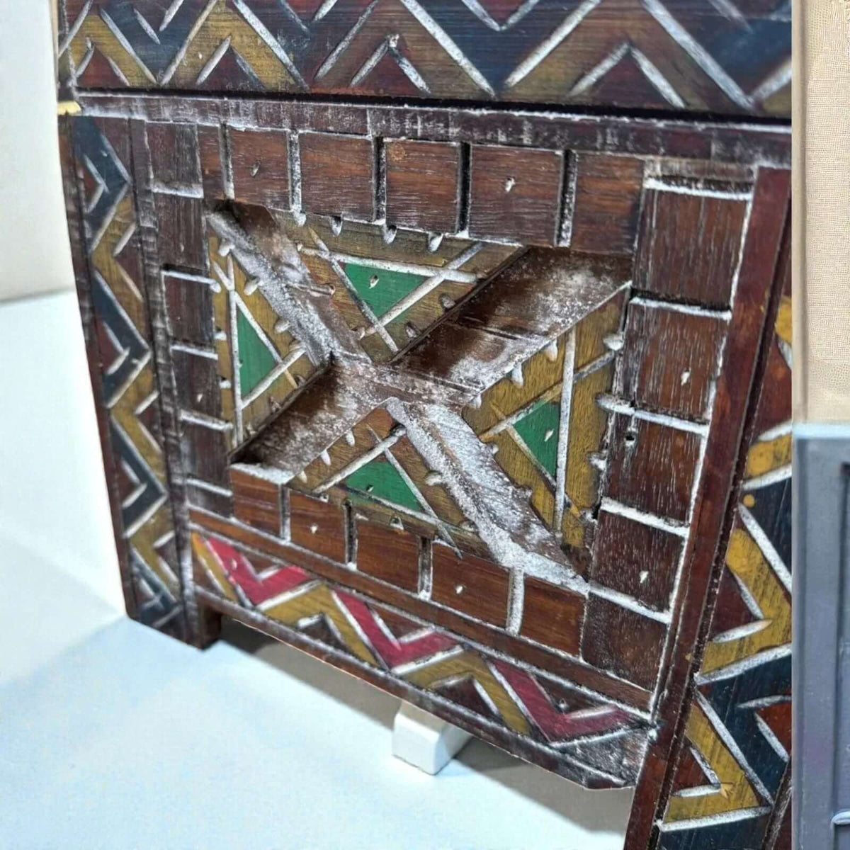 AtlasMuseCrafts custom Moroccan wood cabinet with intricate Berber carvings in red, yellow, green, and white.