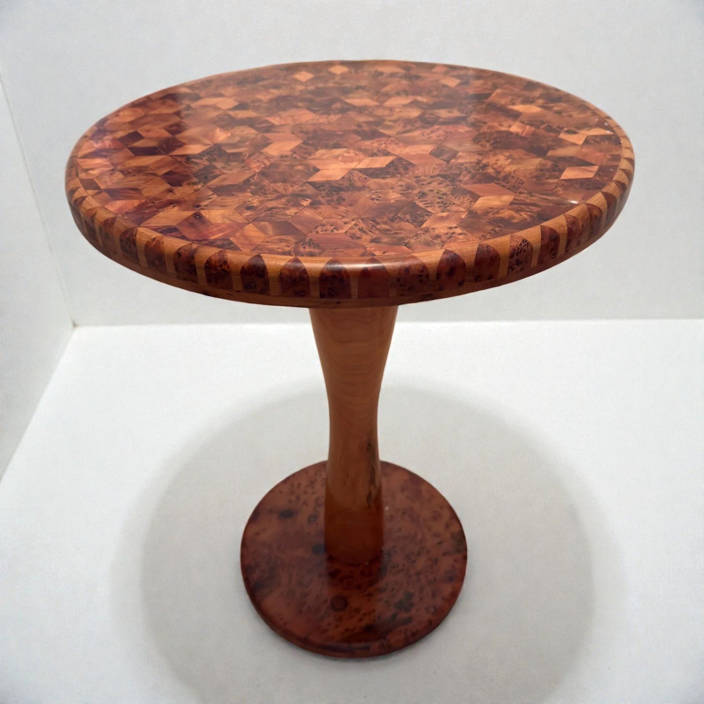 AtlasMuseCrafts handmade round solid wood coffee table with a mosaic wood top and pedestal base. Natural wood finish.