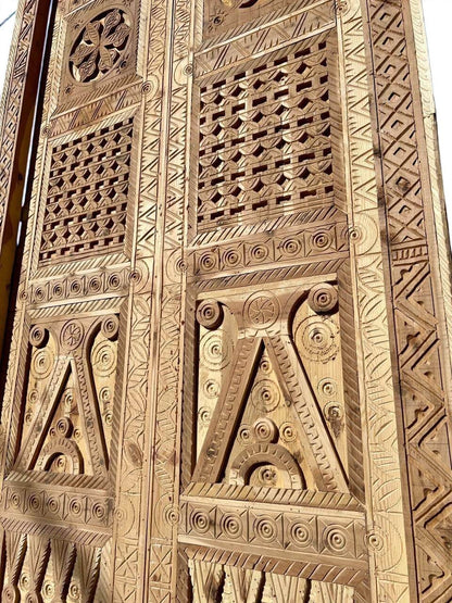 AtlasMuseCrafts antique double wooden door with intricate Moorish hand-carving and geometric patterns.