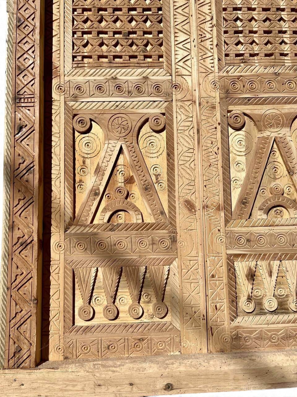 AtlasMuseCrafts antique double wooden door with intricate Moorish hand-carving and geometric patterns.