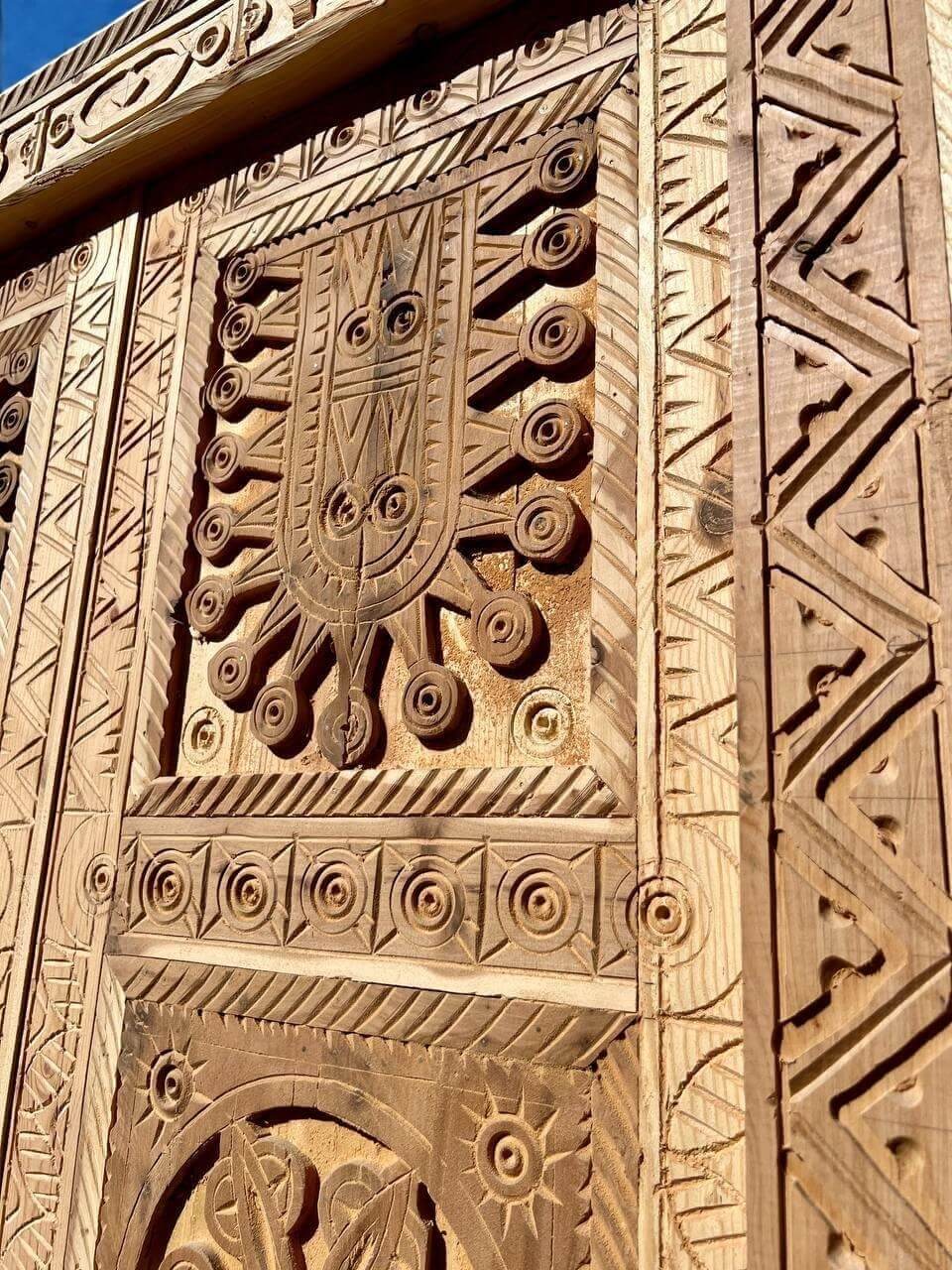 AtlasMuseCrafts antique double wooden door with intricate Moorish hand-carving and geometric patterns.