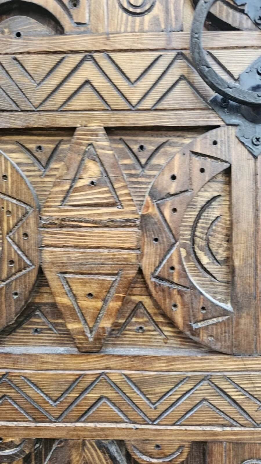AtlasMuseCrafts antique Moroccan door, natural wood with intricate Berber carving and metal hardware detail.
