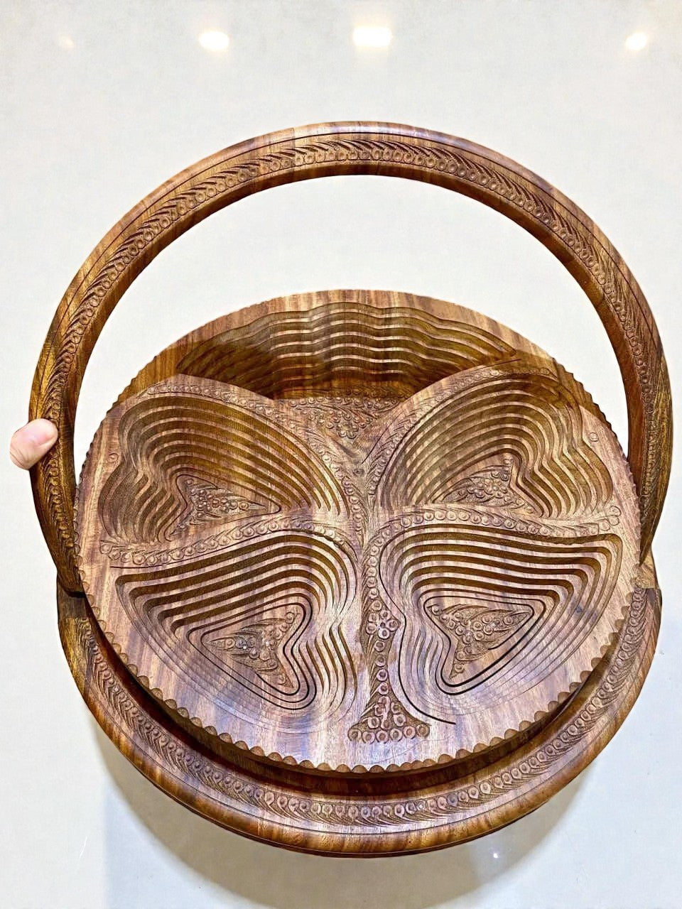 AtlasMuseCrafts handmade folding wooden fruit basket with intricate carved details and a curved handle. Rich walnut wood.