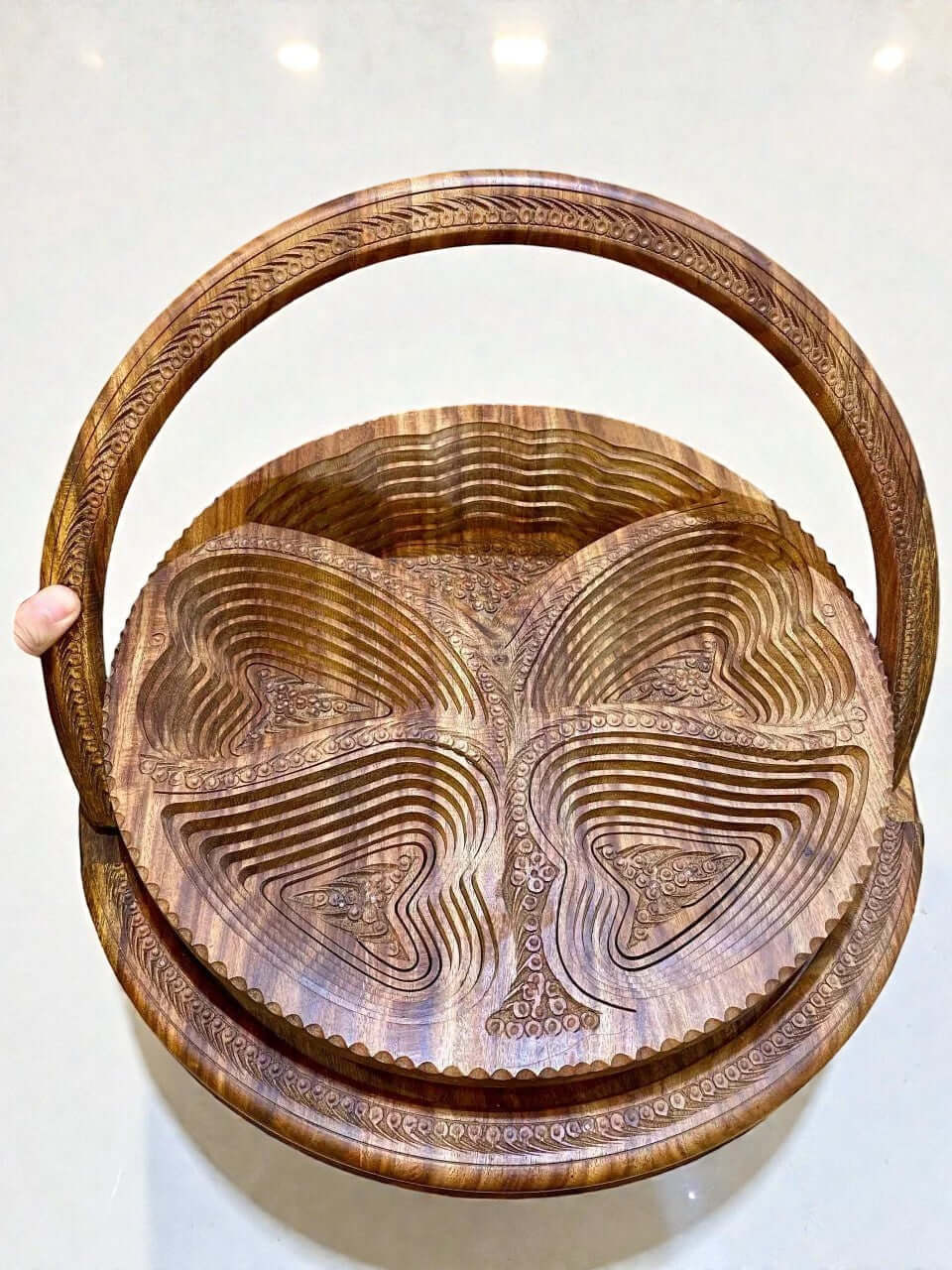 Folding walnut wood fruit basket with carved details and curved handle