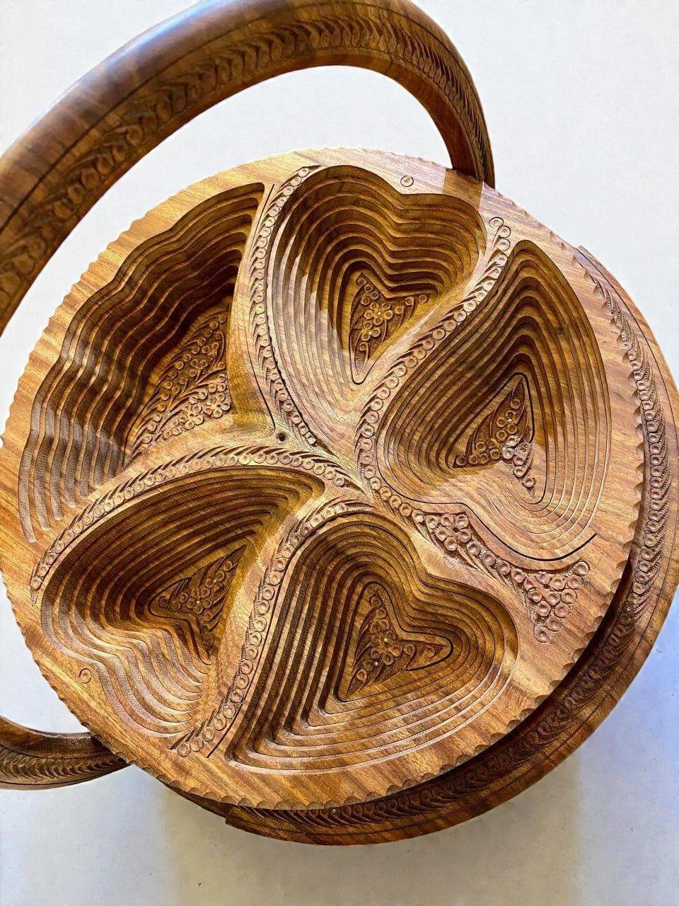AtlasMuseCrafts handmade folding wooden fruit basket with carved floral details and handle, natural wood finish.