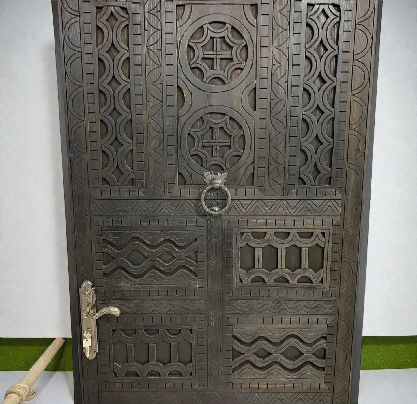 AtlasMuseCrafts dark wood door with intricate traditional floral carvings and brass hardware.