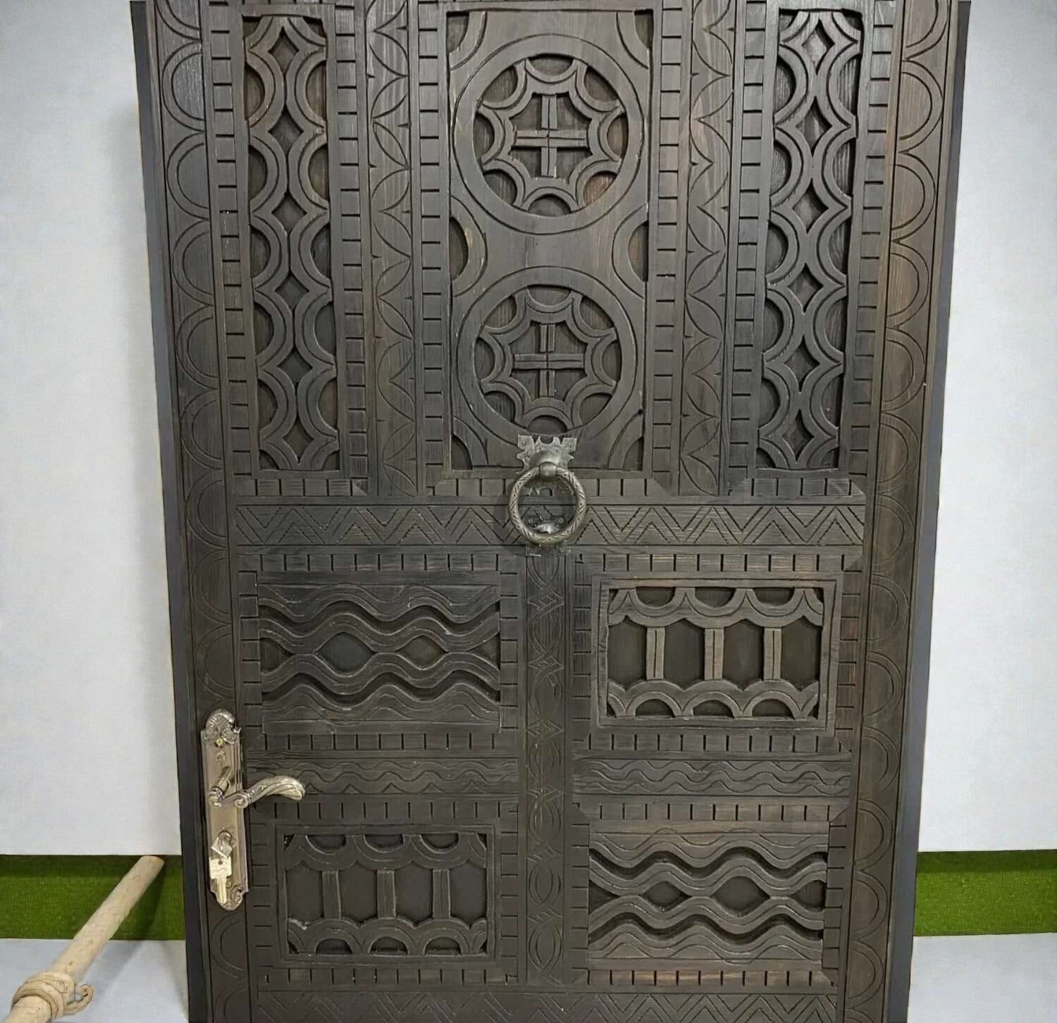 AtlasMuseCrafts dark wood door with intricate traditional floral carvings and brass hardware.