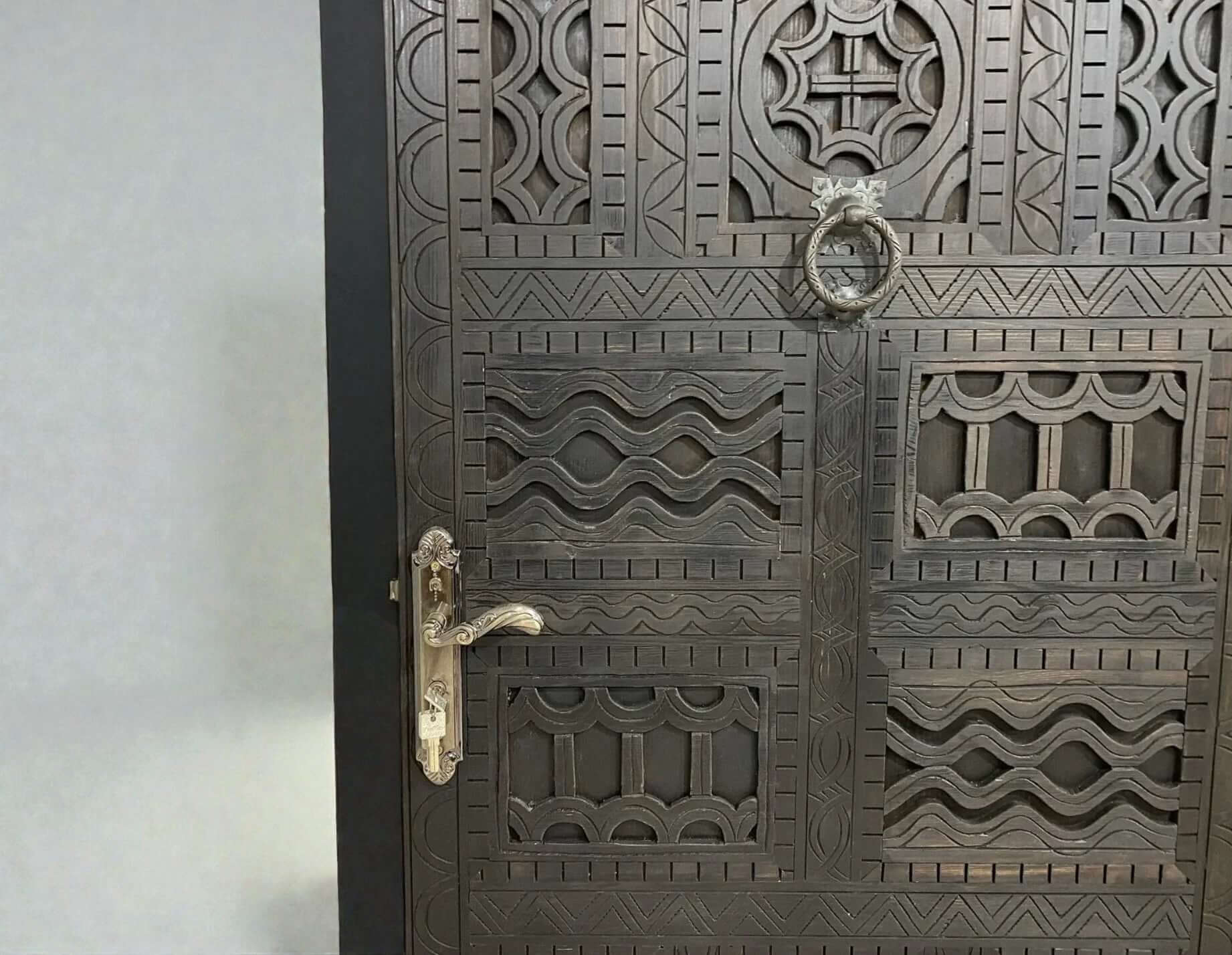 AtlasMuseCrafts dark wood door with intricate traditional floral carvings and metal hardware.