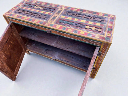 AtlasMuseCrafts handmade wooden cabinet with colorful Berber carvings and rustic boho style. Features open doors revealing shelves.