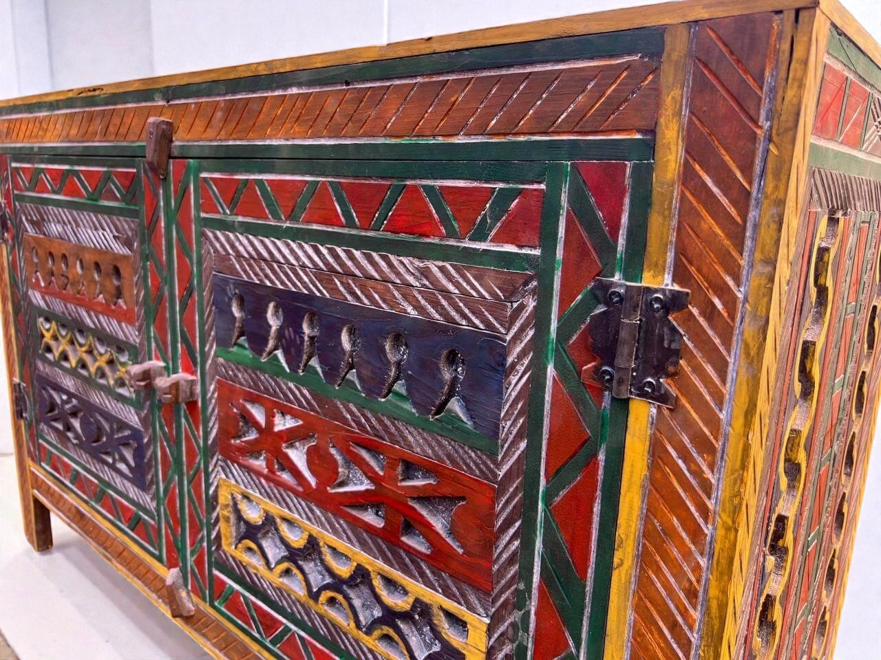 AtlasMuseCrafts handmade wooden cabinet with colorful Berber carvings and rustic boho style. Features intricate patterns, red, green, yellow, and blue accents.