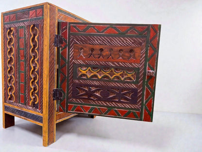 AtlasMuseCrafts handmade wooden cabinet with intricate Berber carvings and colorful geometric patterns. Features hand-painted details in red, green, and orange.