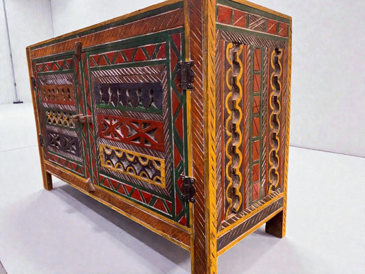 AtlasMuseCrafts handmade wooden cabinet with intricate Berber carvings in red, green, yellow, and dark blue. Rustic boho style storage.