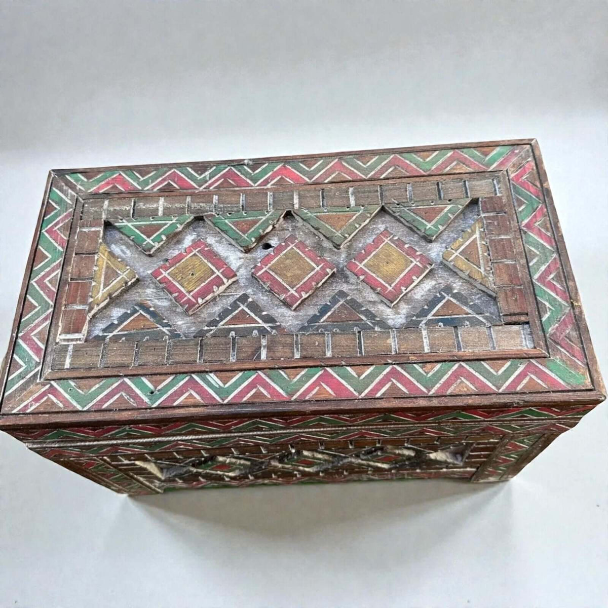 AtlasMuseCrafts handmade wooden storage cabinet with carved Berber patterns in red, green, and yellow. Rustic boho style.