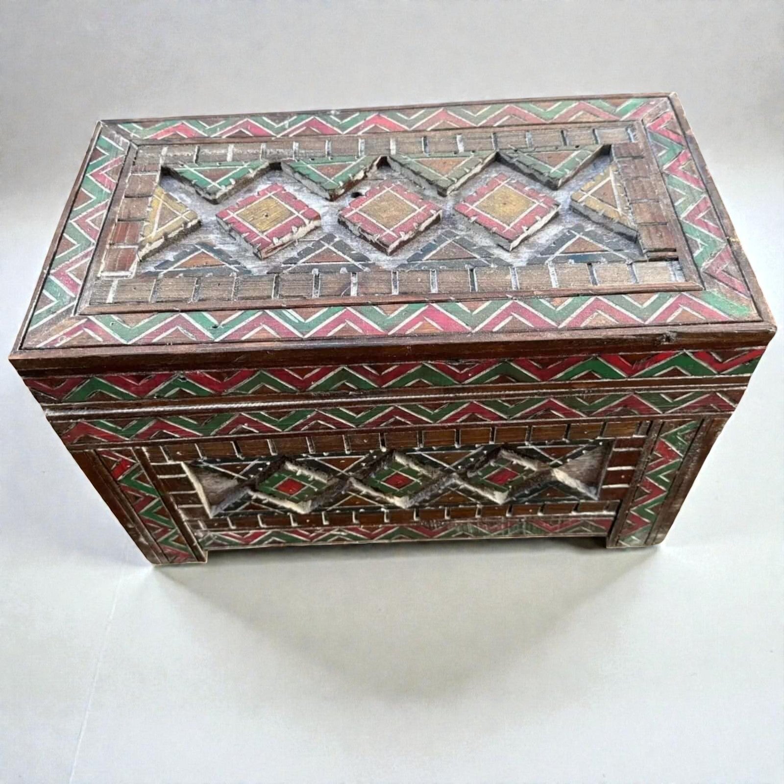 AtlasMuseCrafts handmade wooden storage cabinet with carved Berber patterns in red, green, and yellow.