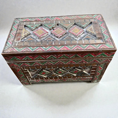 AtlasMuseCrafts handmade wooden storage cabinet with carved Berber patterns in red, green, and yellow.