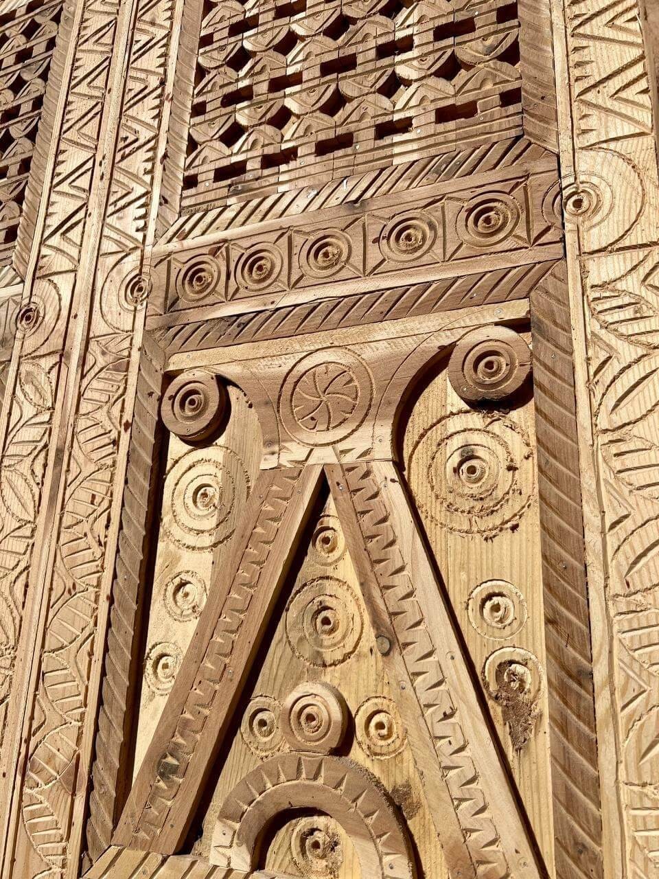 AtlasMuseCrafts natural wood double door with intricate Moorish hand-carving, geometric patterns, and arabesques.