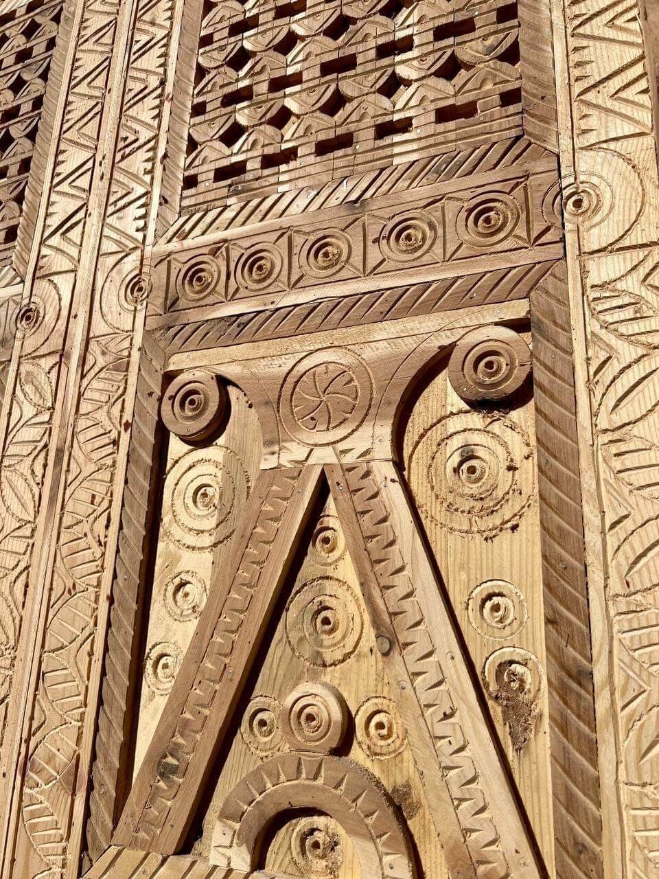 AtlasMuseCrafts natural wood double door with intricate Moorish hand-carving, geometric patterns, and arabesques.