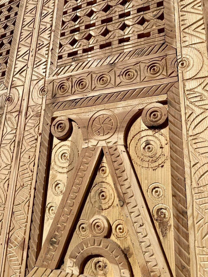 AtlasMuseCrafts natural wood double door with intricate Moorish hand-carving, geometric patterns, and arabesques.