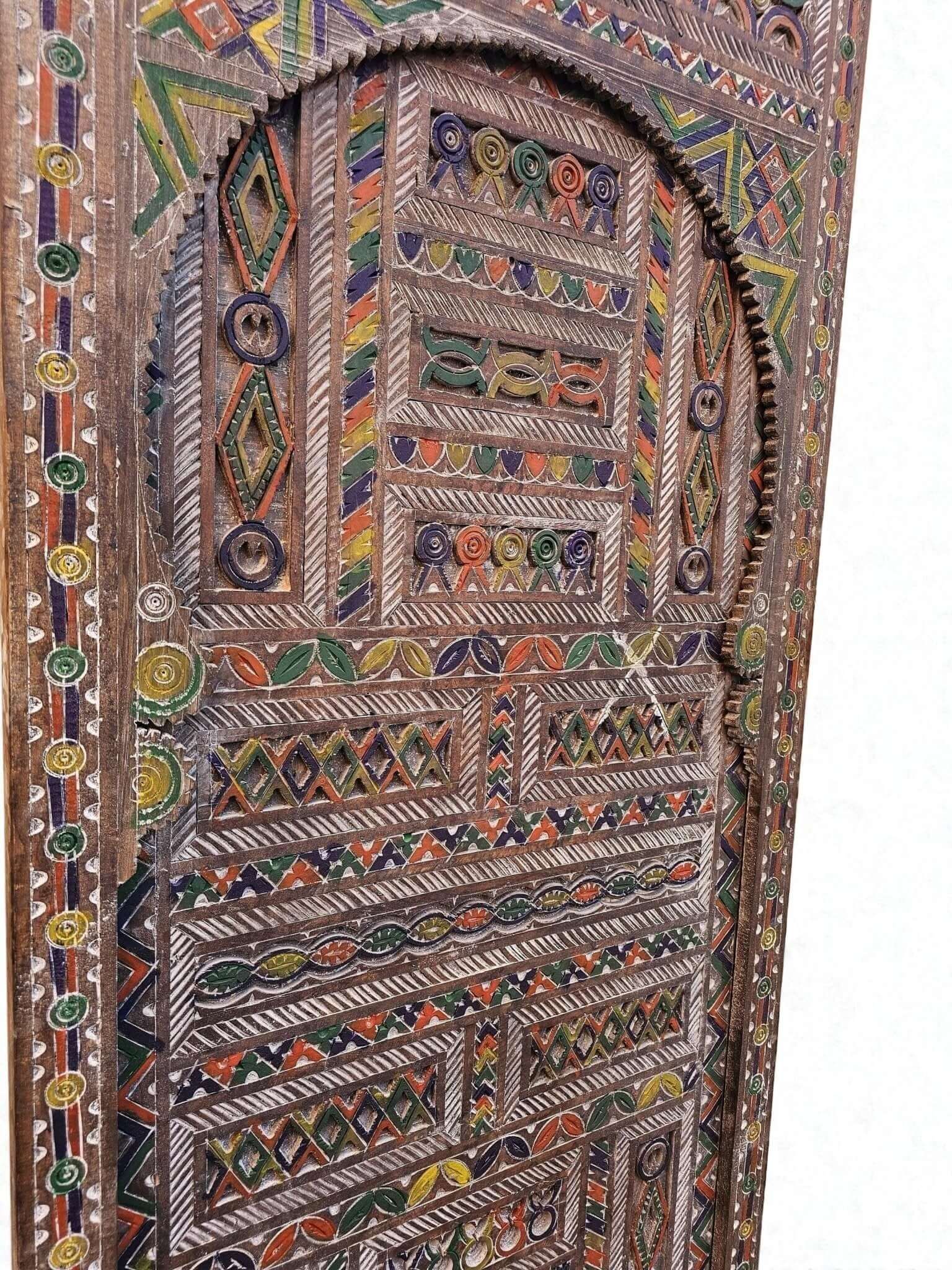 AtlasMuseCrafts Moroccan antique style door with intricate hand-carving and colorful geometric patterns on natural wood.
