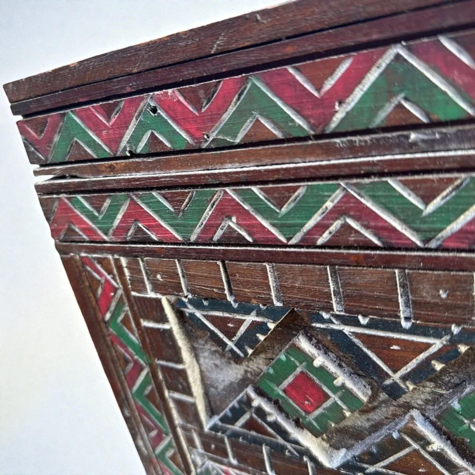 AtlasMuseCrafts handmade Moroccan cabinet with carved Berber patterns in red and green on dark wood.
