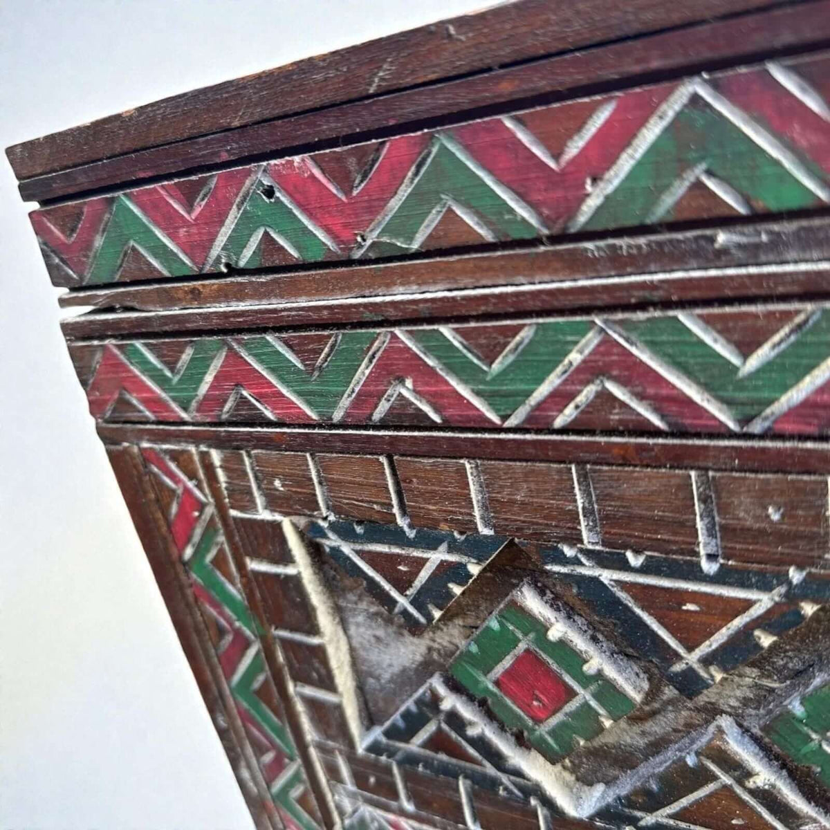 AtlasMuseCrafts handmade Moroccan cabinet with carved Berber patterns in red and green on dark wood.