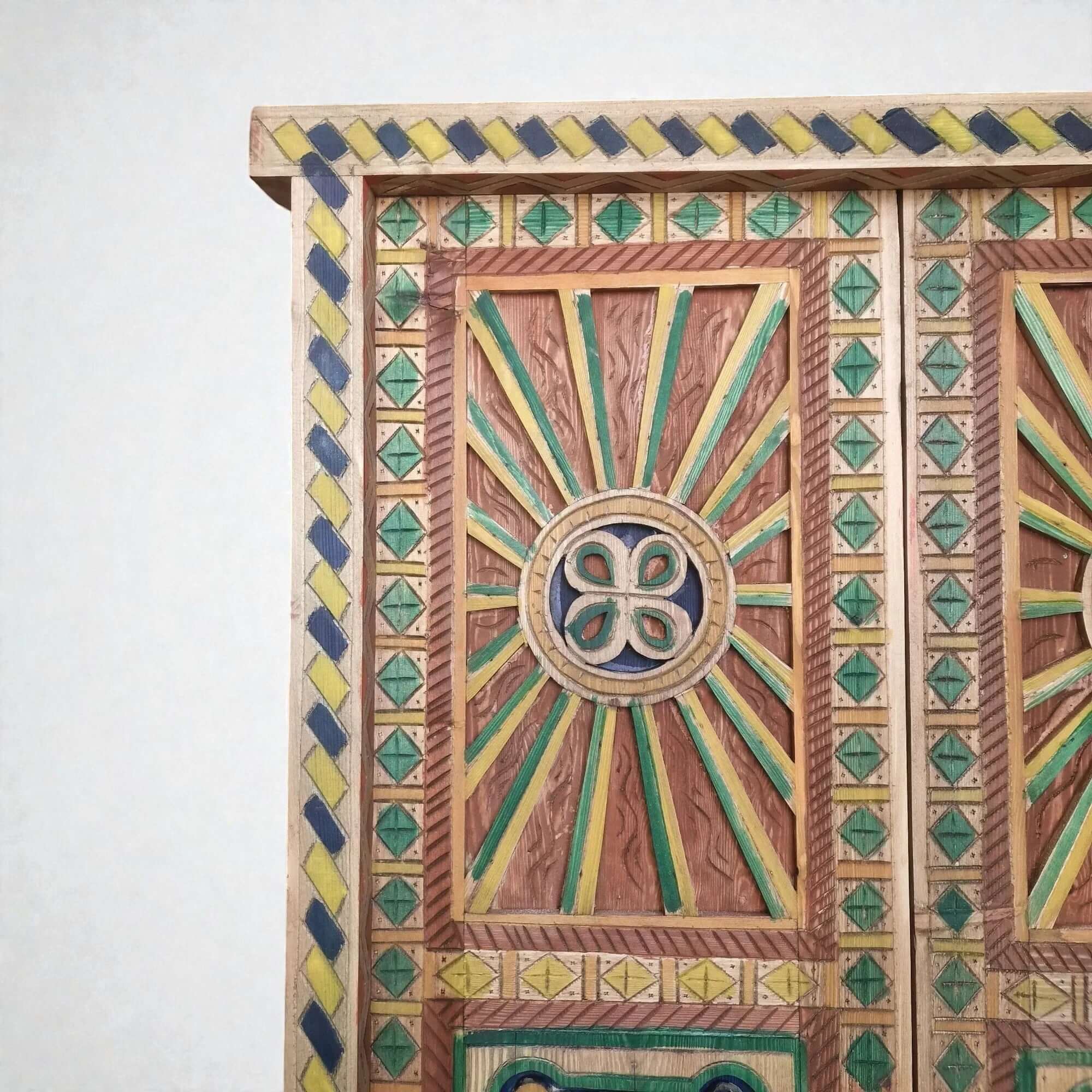AtlasMuseCrafts hand-painted multicolor Moroccan door with geometric carving in wood. Features sunbursts and diamond patterns.